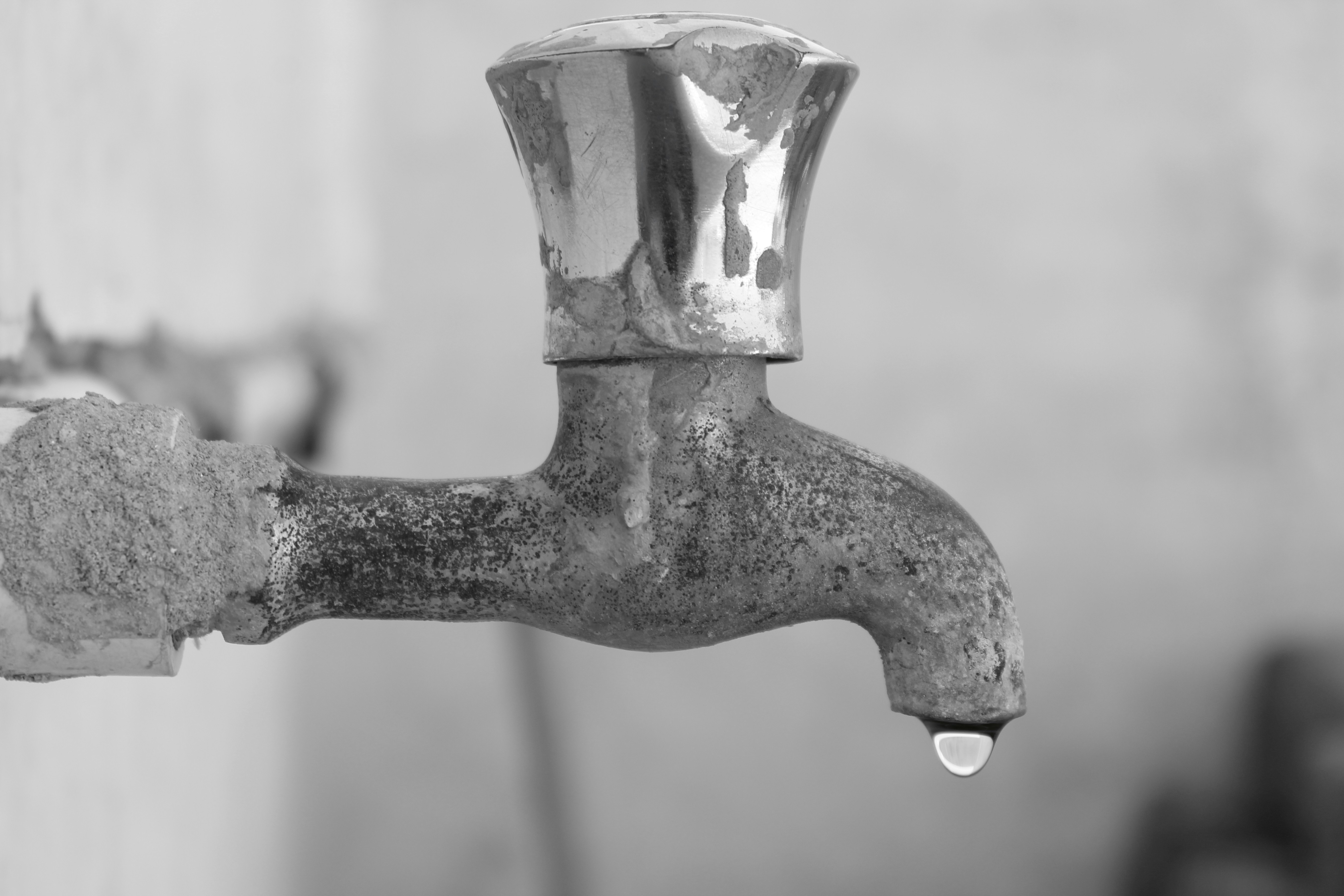 Water conservation - old faucet with water droplet